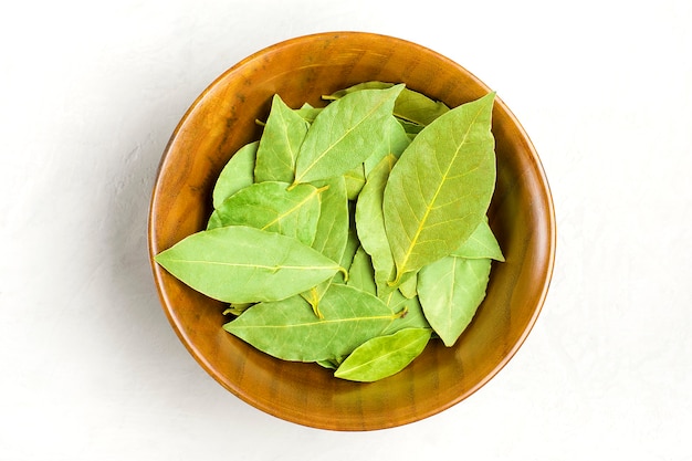 Mise à plat de la feuille de laurier dans un bol en bois