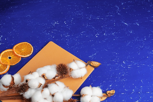 Mise à plat de fond bleu féminin avec branche de fleur de coton artificiel