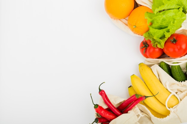 Photo mise à plat de fruits et légumes dans des sacs réutilisables avec espace copie