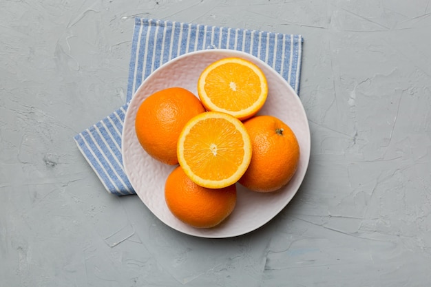 Mise à plat de fruits orange frais avec des tranches dans une assiette sur fond coloré Vue de dessus avec espace de copie