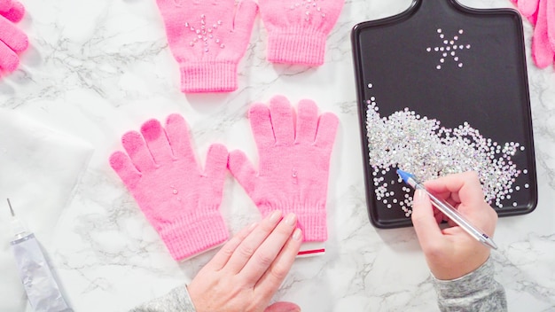Mise à plat. Gants enfant rose strass en forme de flocon de neige.