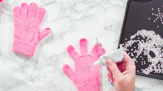 Mise à plat. Gants enfant rose strass en forme de flocon de neige.