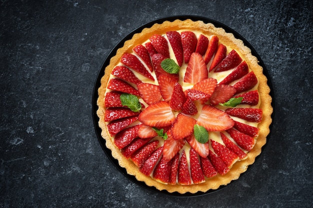 Mise à plat de gâteau aux fraises fraîches d'en haut sur fond noir