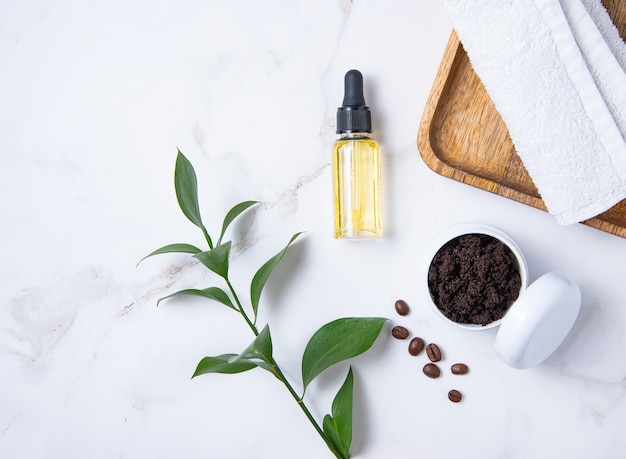 Mise à plat avec des ingrédients naturels pour gommage au café à la maison avec de l'huile d'olive sur fond de marbre. Soins de la peau du corps. Vue de dessus et espace de copie