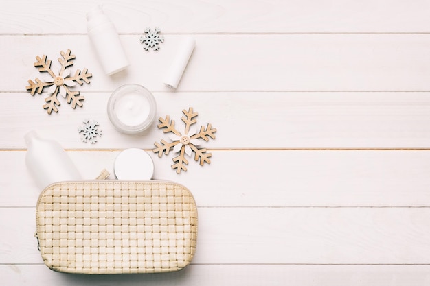 Mise à plat de Noël avec des produits cosmétiques de maquillage dans un sac cosmétique sur fond coloré Vue de dessus Concept de beauté du nouvel an