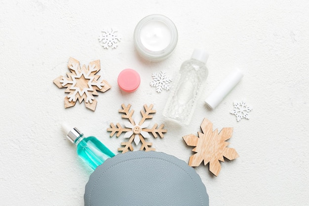 Mise à plat de Noël avec des produits cosmétiques de maquillage dans un sac cosmétique sur fond coloré Vue de dessus Concept de beauté du nouvel an