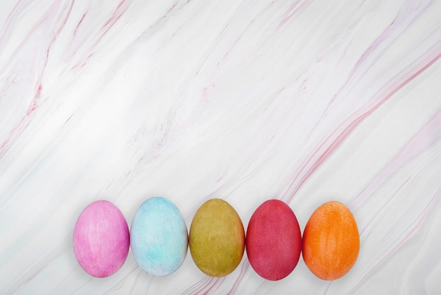 Mise à plat d'oeufs de Pâques colorés sur fond de marbre Texture de marbre de Pâques avec des oeufs colorés