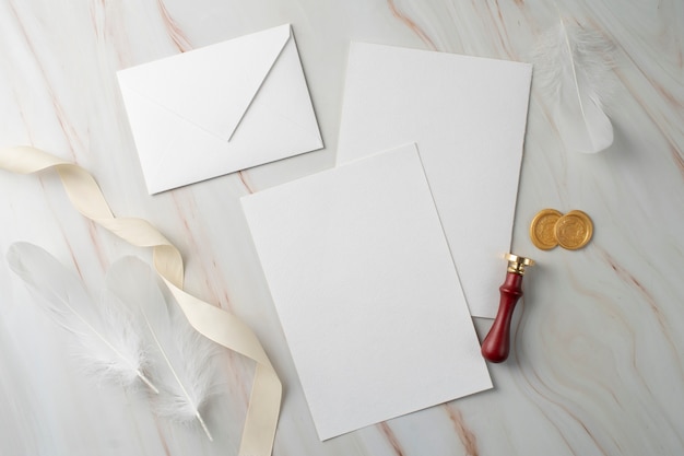 Photo mise à plat de papier de mariage et enveloppe avec ruban et sceau