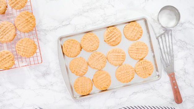 Mise à plat. Pas à pas. Biscuits au beurre d'arachide fraîchement cuits sur une plaque à pâtisserie.