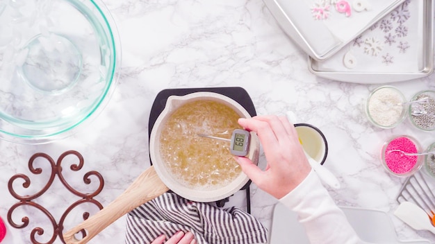 Mise à plat. Pas à pas. Faire caraméliser le sucre dans une petite marmite au-dessus de la petite cuisinière électrique.