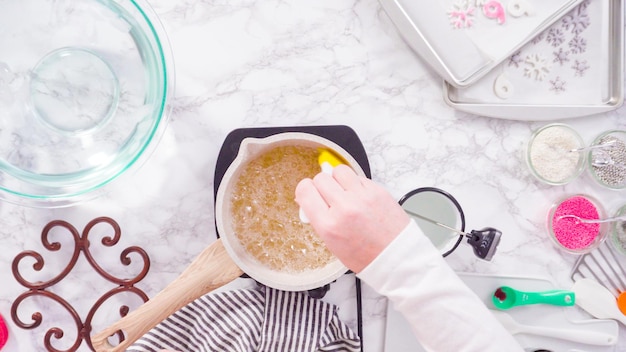 Mise à plat. Pas à pas. Faire caraméliser le sucre dans une petite marmite au-dessus de la petite cuisinière électrique.