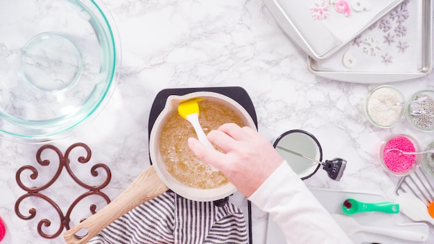 Mise à plat. Pas à pas. Faire caraméliser le sucre dans une petite marmite au-dessus de la petite cuisinière électrique.