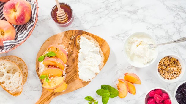 Mise à plat. Pas à pas. Faire des toasts à la ricotta avec des pêches et des baies biologiques.