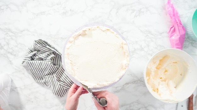 Mise à plat. Pas à pas. Glaçage gâteau funfetti rond avec glaçage à la crème au beurre italienne blanche.