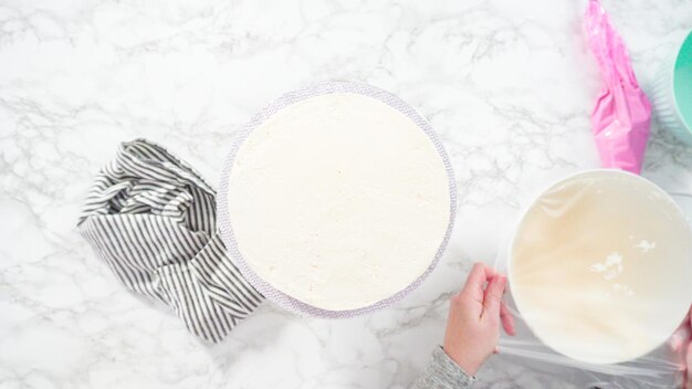 Mise à plat. Pas à pas. Glaçage gâteau funfetti rond avec glaçage à la crème au beurre italienne blanche.