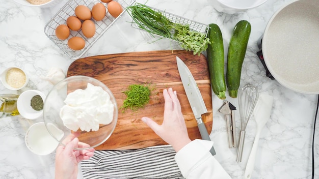 Mise à plat. Pas à pas. Mélanger des herbes fraîches et de la crème sure pour faire de la crème sure aux herbes.