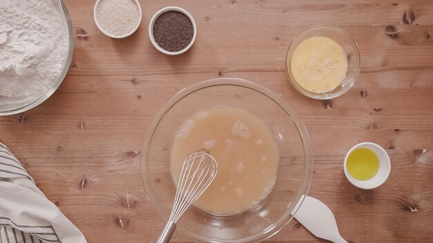 Mise à plat. Pas à pas. Mélanger des ingrédients biologiques dans le bol en verre pour cuire la challah.