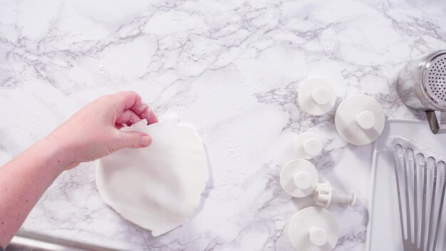 Mise à plat. Pas à pas. Rouler notre fondant blanc sur un comptoir en marbre.