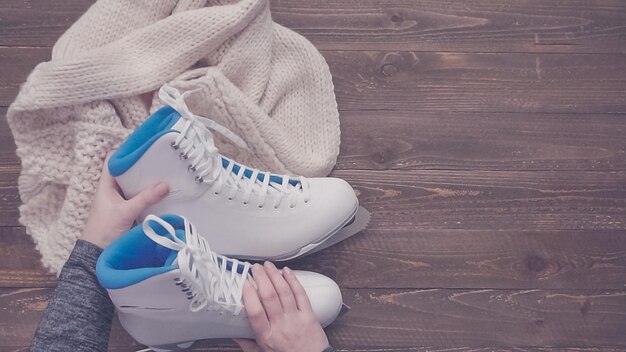 Mise à plat. Patins blancs sur une planche en bois.