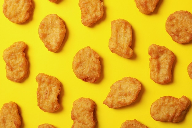 Mise à plat avec des pépites de poulet frit sur fond jaune