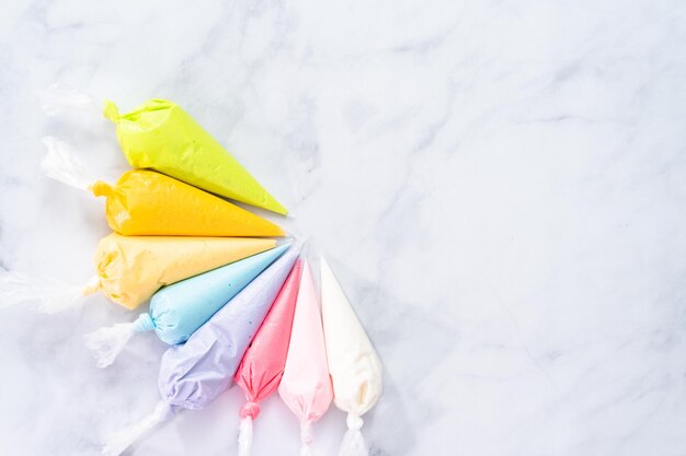 Mise à plat. Poches à douille avec glaçage royal de couleur pastel pour décorer les biscuits au sucre de Pâques.