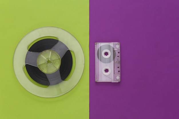 Mise à plat rétro. Bobine de bande magnétique audio et cassette audio sur un vert violet