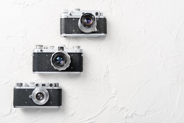 Mise à plat de trois anciens appareils photo vintage sur fond blanc avec espace libre pour la maquette de texte