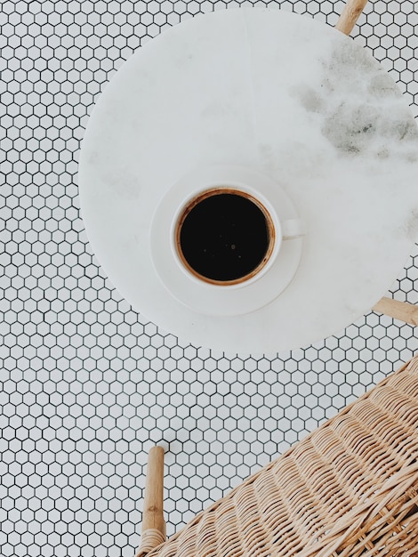 Mise à plat, vue de dessus d'une tasse de café sur une table en marbre ronde blanche