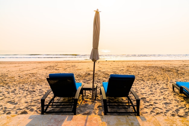 Photo mmbrella chaise plage avec palmier et plage de la mer