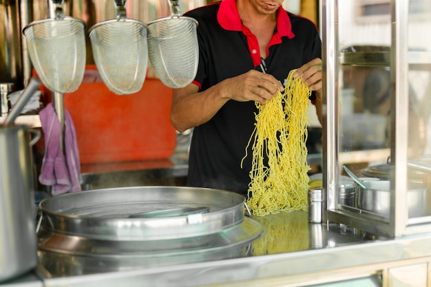 Mna prépare des nouilles aux œufs pour cuisiner des vendeurs d'aliments de rue.