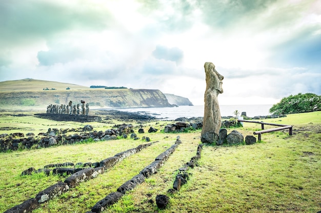 Photo moai ha'ere ki haho la statue itinérante à l'entrée de la zone d'ahu tongariki sur la célèbre île de pâques au chili concept de voyage wanderlust filtre vert vif sur ciel nuageux dramatique