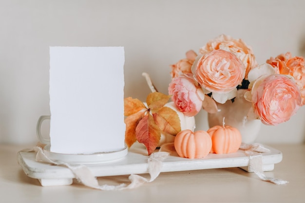 mocap d'une feuille de papier aquarelle sur fond d'automne avec des bougies et des roses aux couleurs roses