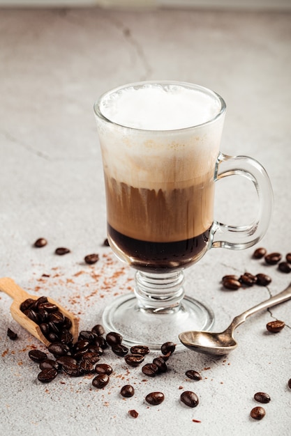 Moccacino café en couches avec du chocolat dans une tasse en verre sur la surface en béton