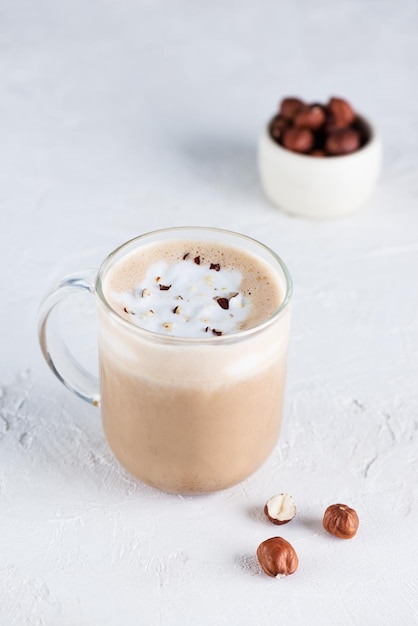 Mochaccino végétalien au chocolat, noisettes et lait de coco dans une tasse en verre.