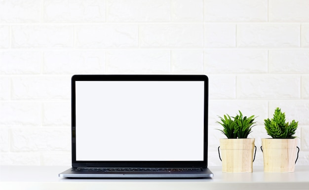 mock up Écran d&#39;ordinateur portable blanc avec des plantes vertes sur le mur de brique chambre blanche