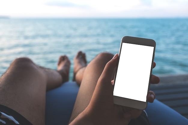 Mockup téléphone intelligent avec des personnes main au bord de la mer