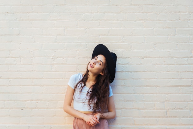 À la mode belle femme adolescente posant avec chapeau