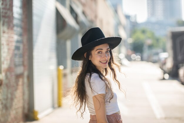 À la mode belle femme adolescente posant avec chapeau