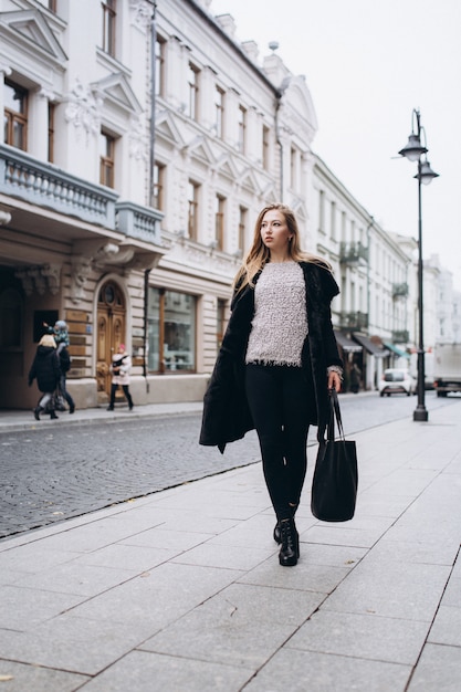 À la mode belle jeune femme blonde posant dans un manteau à la mode à l'extérieur. Beauté, mode, concept de modélisation