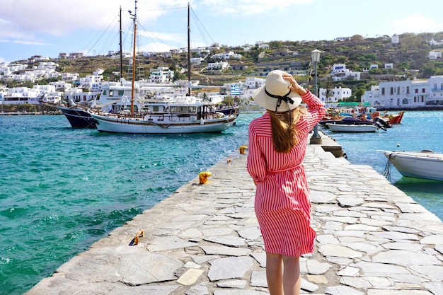 Mode femme marchant sur la jetée du vieux port de Mykonos Grèce