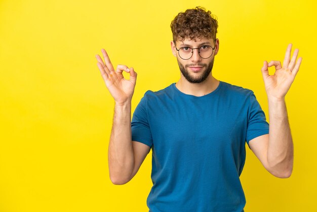 Mode homme afro-américain sur un mur blanc isolé pointant vers le côté pour présenter un produit