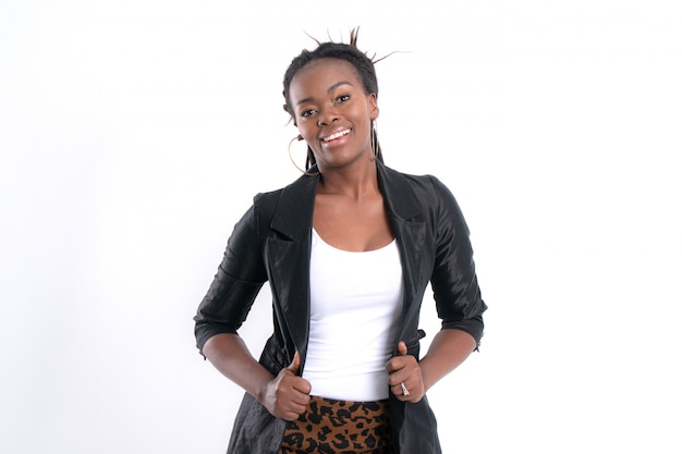 À la mode jeune belle femme africaine avec qui pose en veste en cuir noir.