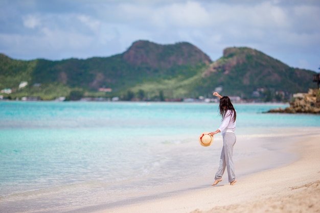 Mode jeune femme au chapeau sur la plage