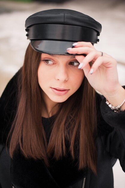 Mode jeune femme en blouson de cuir et casquette