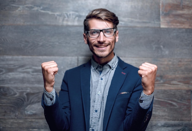 Mode jeune homme souriant en costume sur fond sombre à la recherche de suite