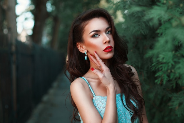 Mode portrait d'une belle femme dans une robe turquoise dans le parc