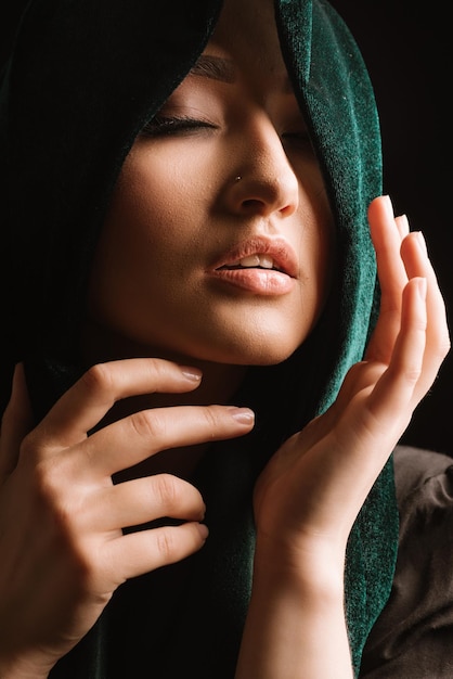 Mode portrait de femme en foulard vert ou hidjab posant sur fond sombre