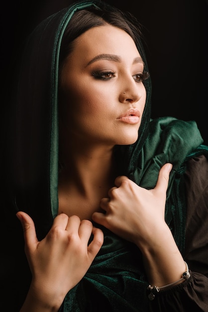 Mode portrait de femme en foulard vert ou hidjab posant sur fond sombre