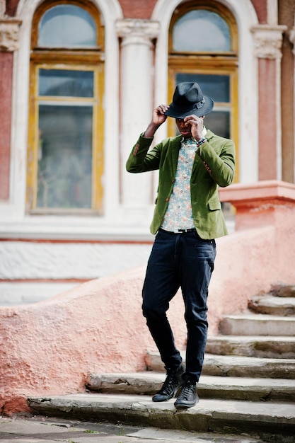 Mode Portrait D'homme Afro-américain Noir Sur Veste De Velours Vert Et Chapeau Noir Rester Sur Fond D'escalier Vieux Manoir Photo Verticale