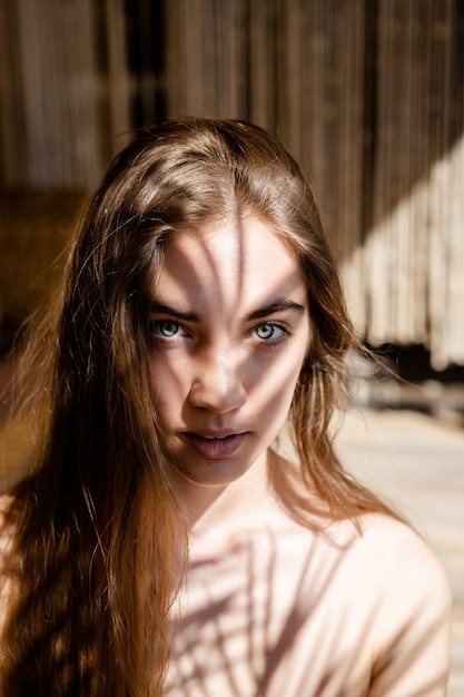 Mode portrait de jeune femme blonde avec des ombres sur son visage. Lumière et ombre. portrait intéressant du visage de la jeune fille couvert d'ombre inhabituelle.